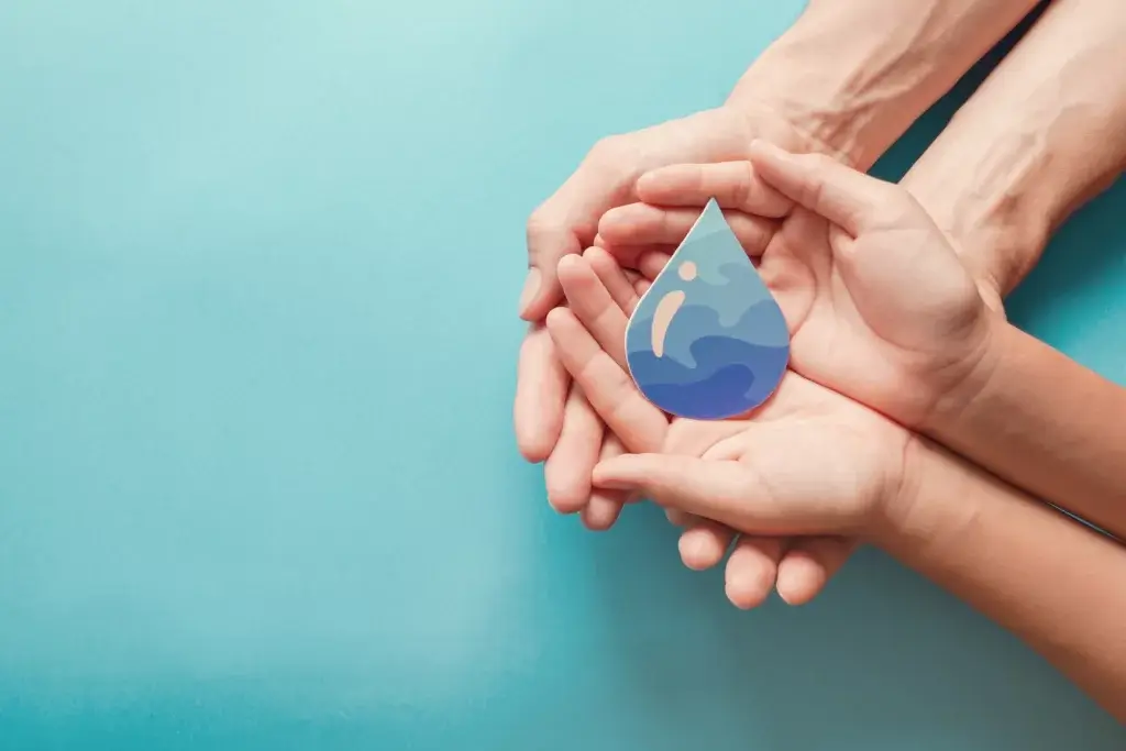 Adult and child hands holding paper cut water drop, World Water